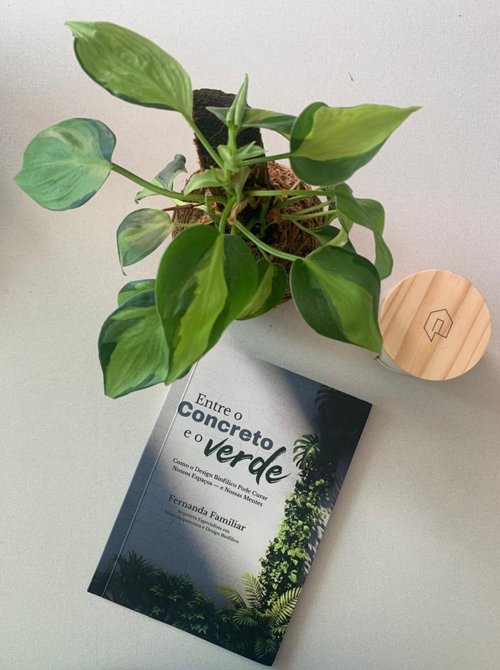 Vista de cima: uma planta com folhas sobre a capa do livro.